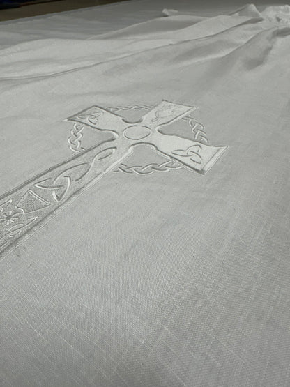 Embroidered cross design on a textured fabric background
